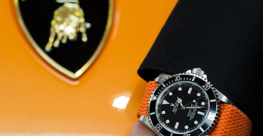 rolex submariner on a orange perlon watch strap and lamborghini