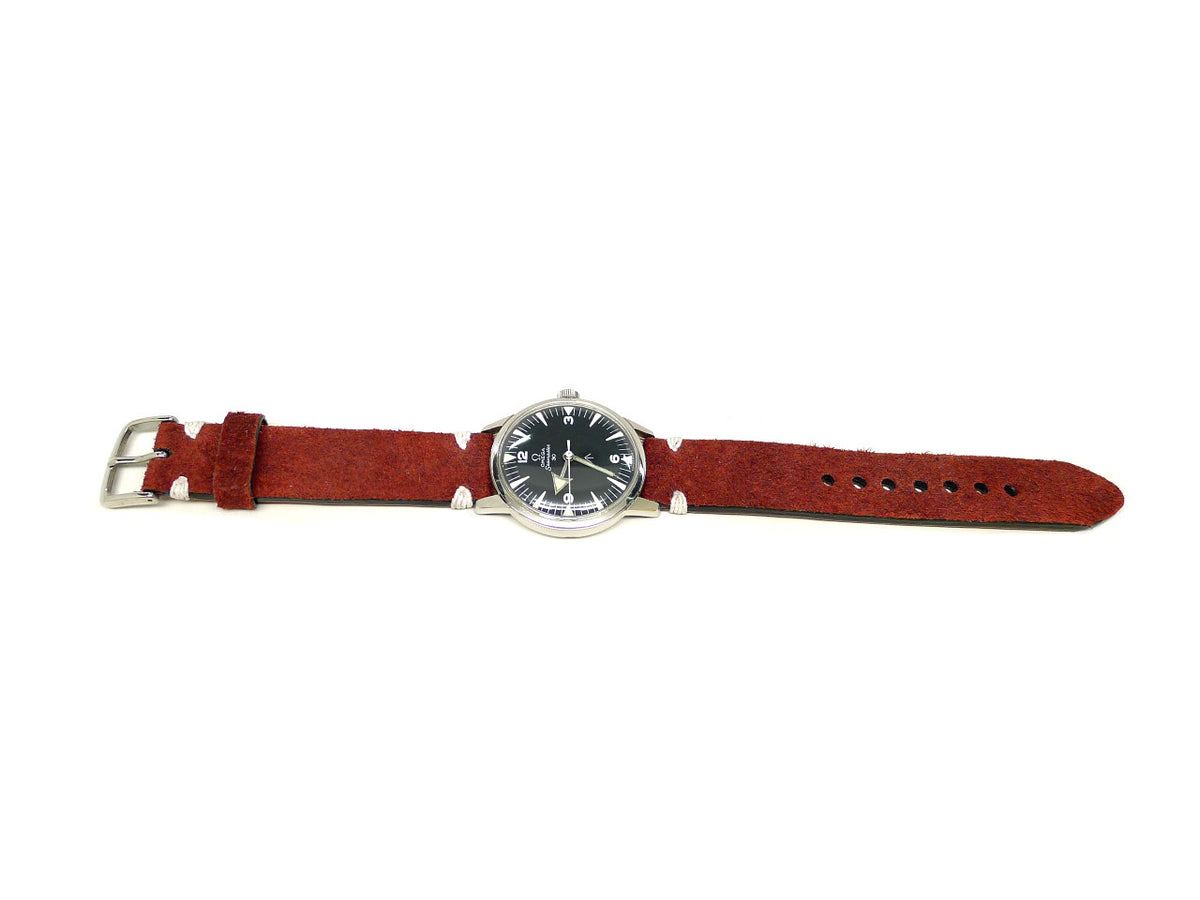 Auxville watch strap in red with a textured surface and white accent stitches, shown fitted to a watch.