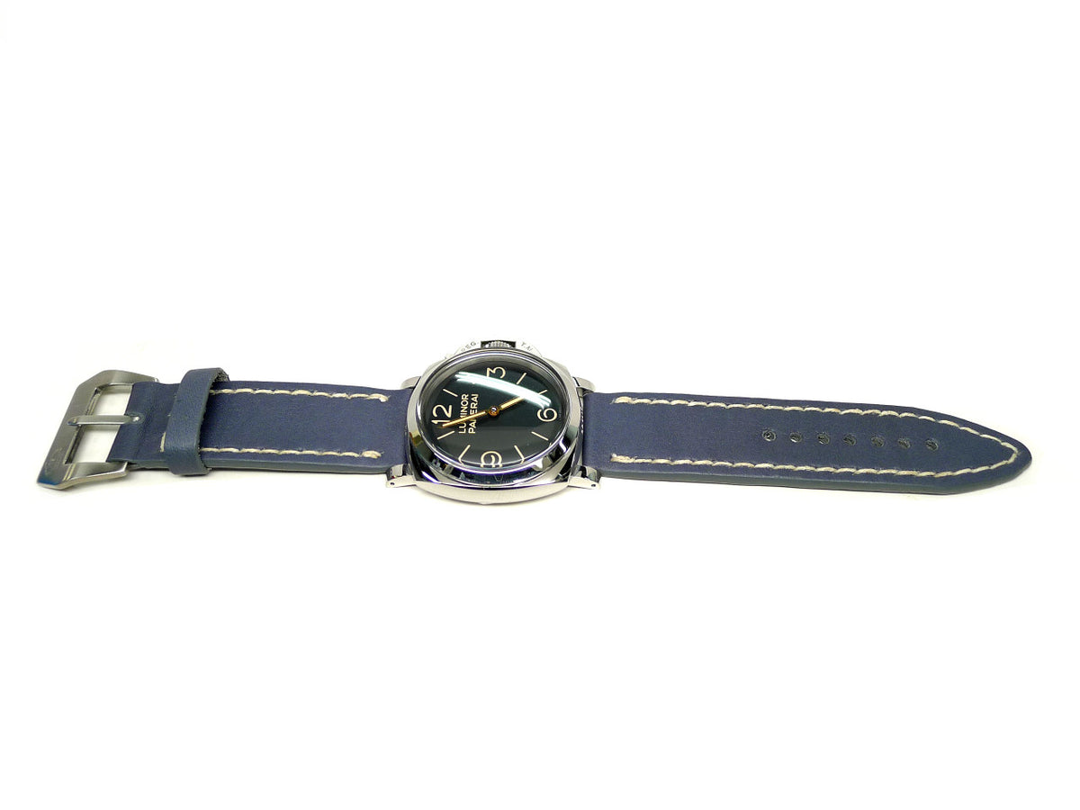 Batshuyi watch strap in dark blue with cream edge stitching, shown fitted to a watch.