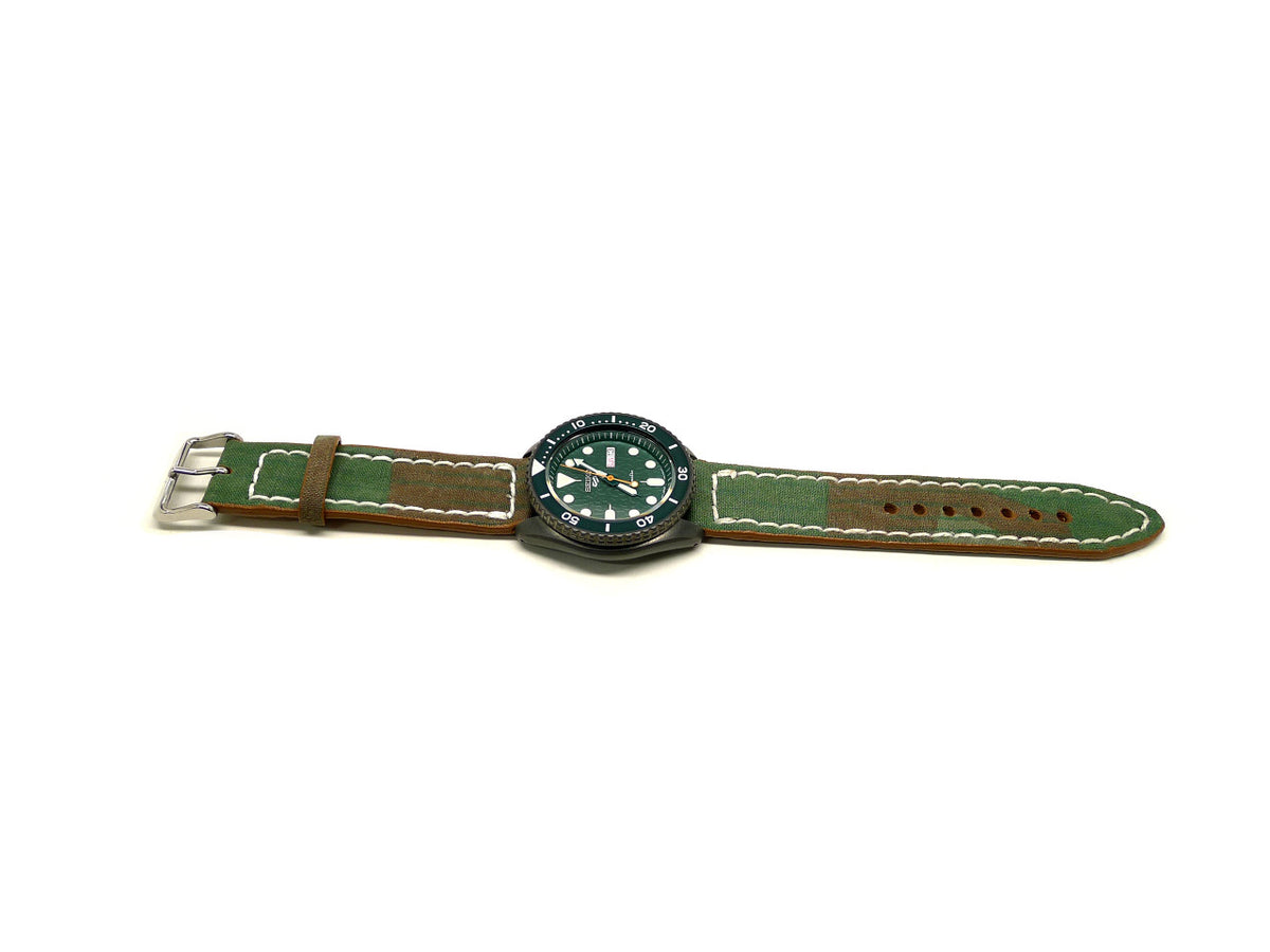Benton watch strap in green with brown edges and white stitching, shown fitted to a watch.