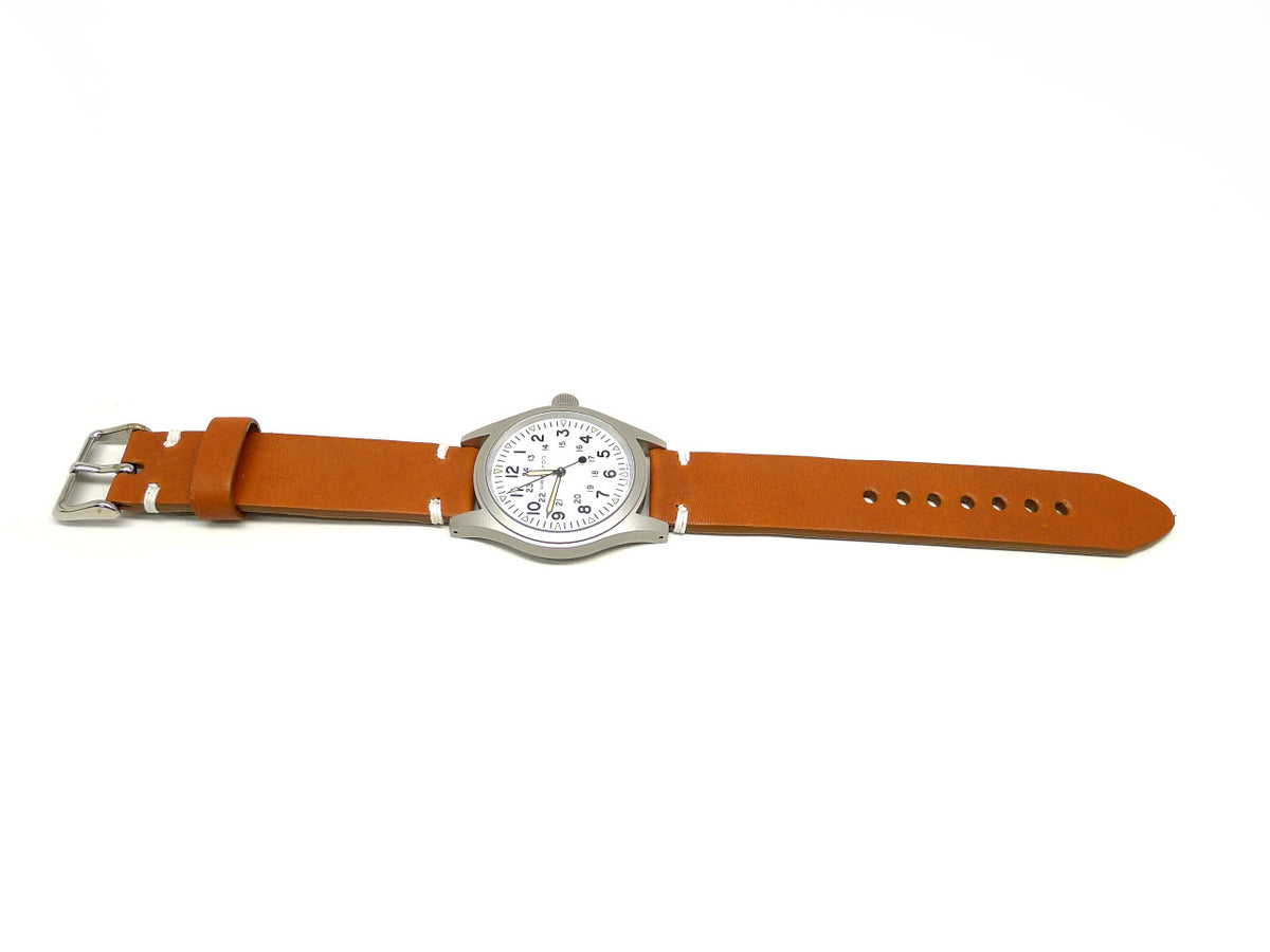 Dontho watch strap in orange brown with white accent stitches, shown fitted to a watch.