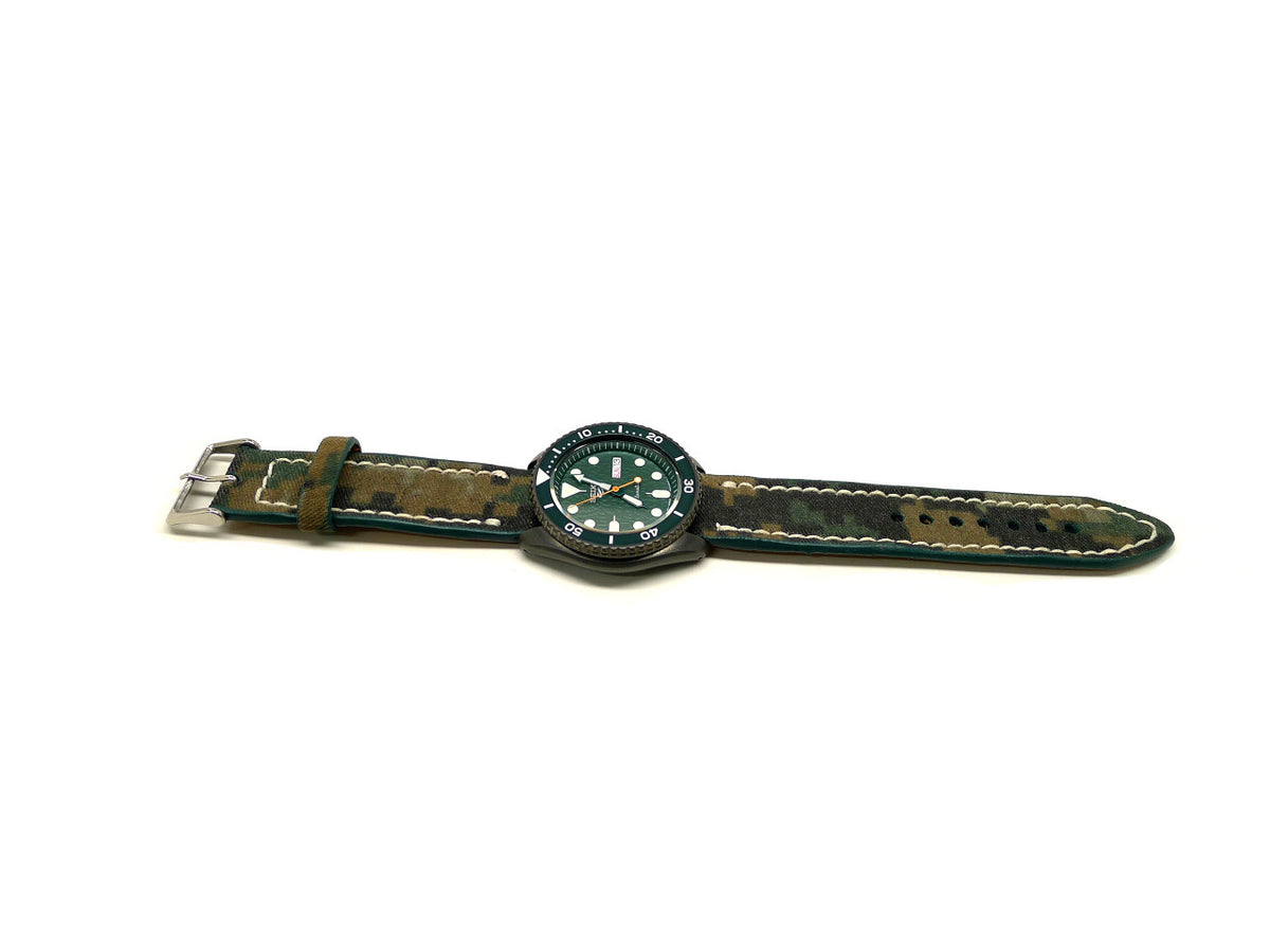 McClary watch strap in green and brown with a camouflage pattern and cream edge stitching, shown fitted to a watch.