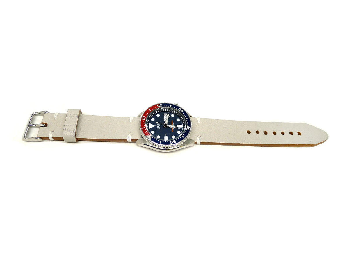 Nanga Parbat watch strap in cream with white accent stitches, shown fitted to a watch.