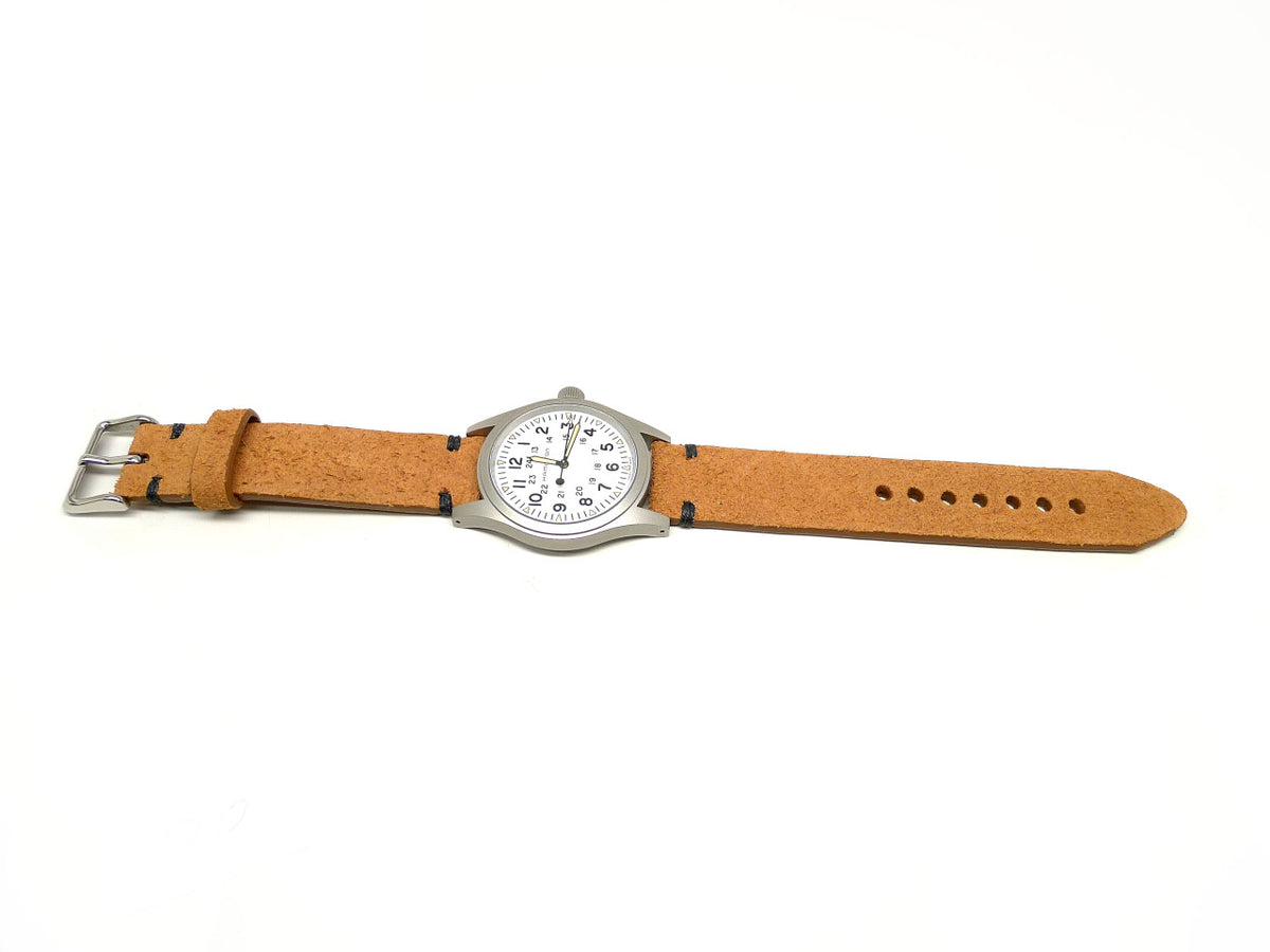 Vhinne watch strap in tan with a textured surface and dark accent stitches, shown fitted to a watch.