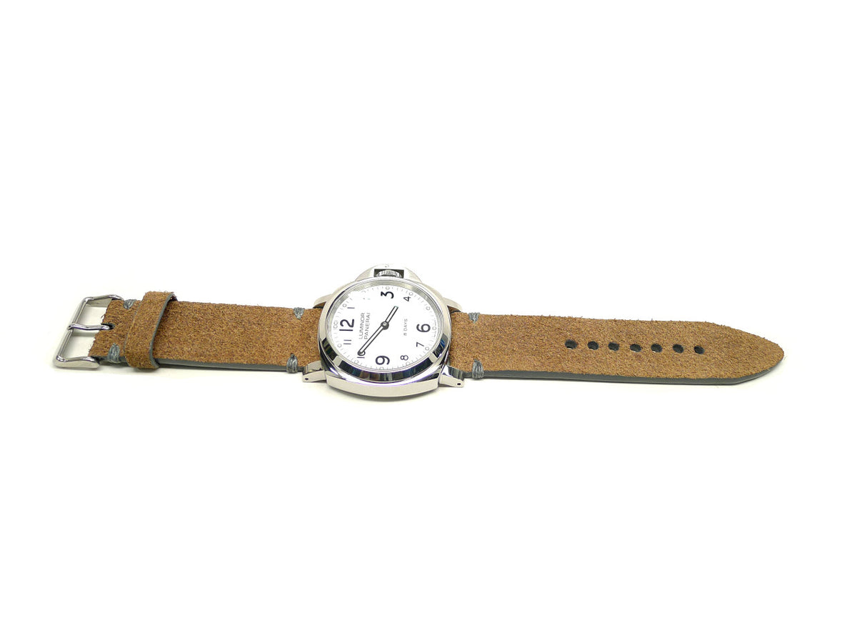 Acquiescence watch strap in tan with a textured surface and gray accent stitches, shown fitted to a watch.