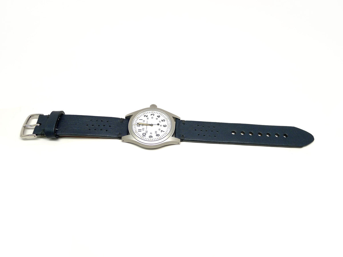 Alsice watch strap in dark blue with small perforations, shown fitted to a watch.
