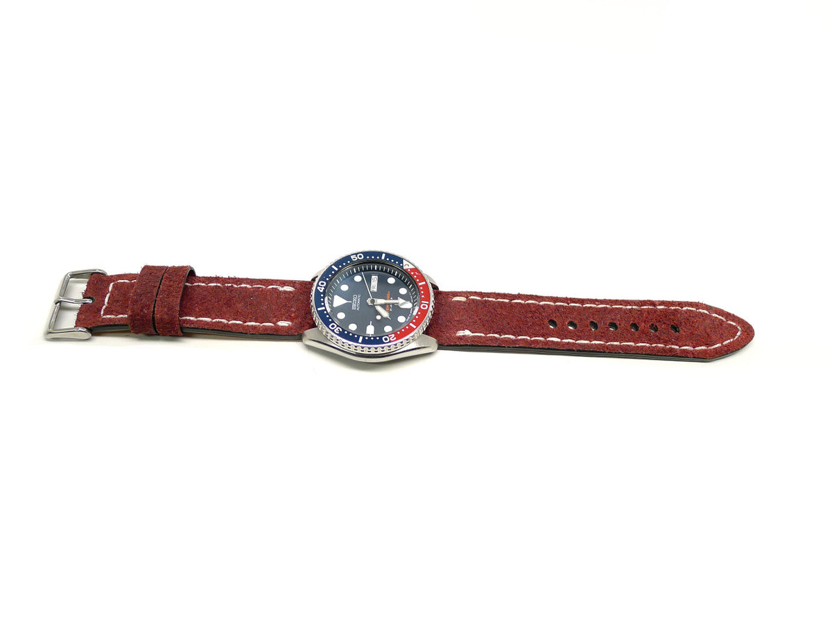 Efloot watch strap in red with a textured surface and cream edge stitching, shown fitted to a watch.