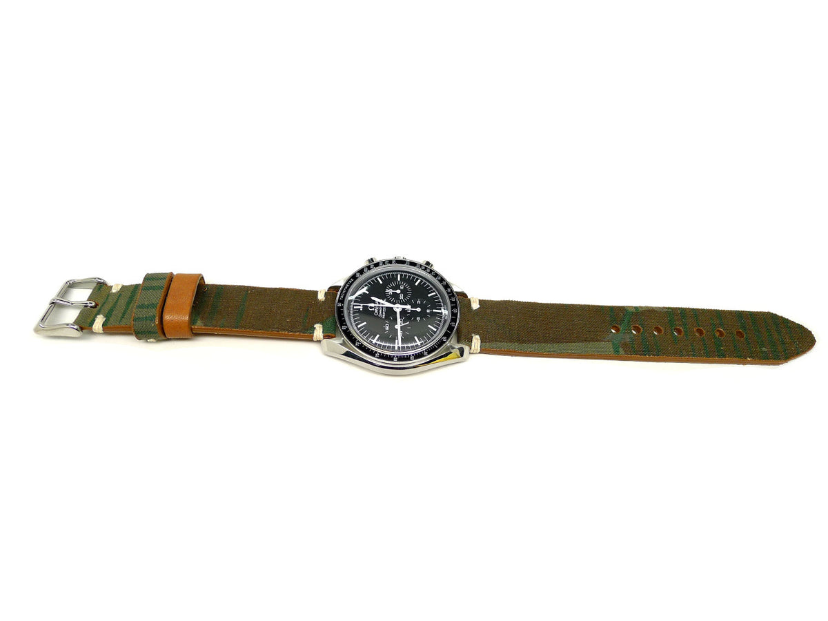 Jungal watch strap in green and brown with streaked markings and an orange keeper, shown fitted to a watch.
