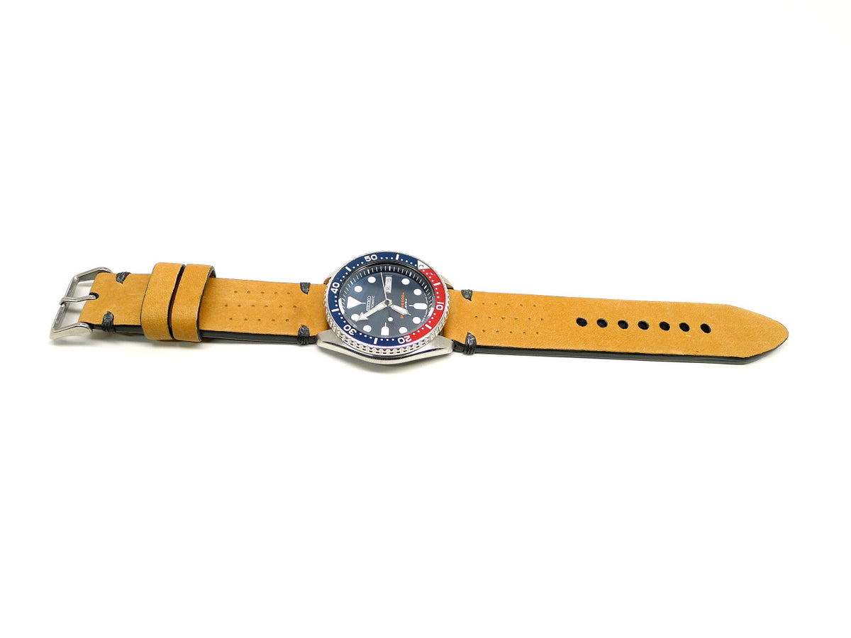 Marchaun watch strap in yellow with small perforations and dark accent stitches, shown fitted to a watch.