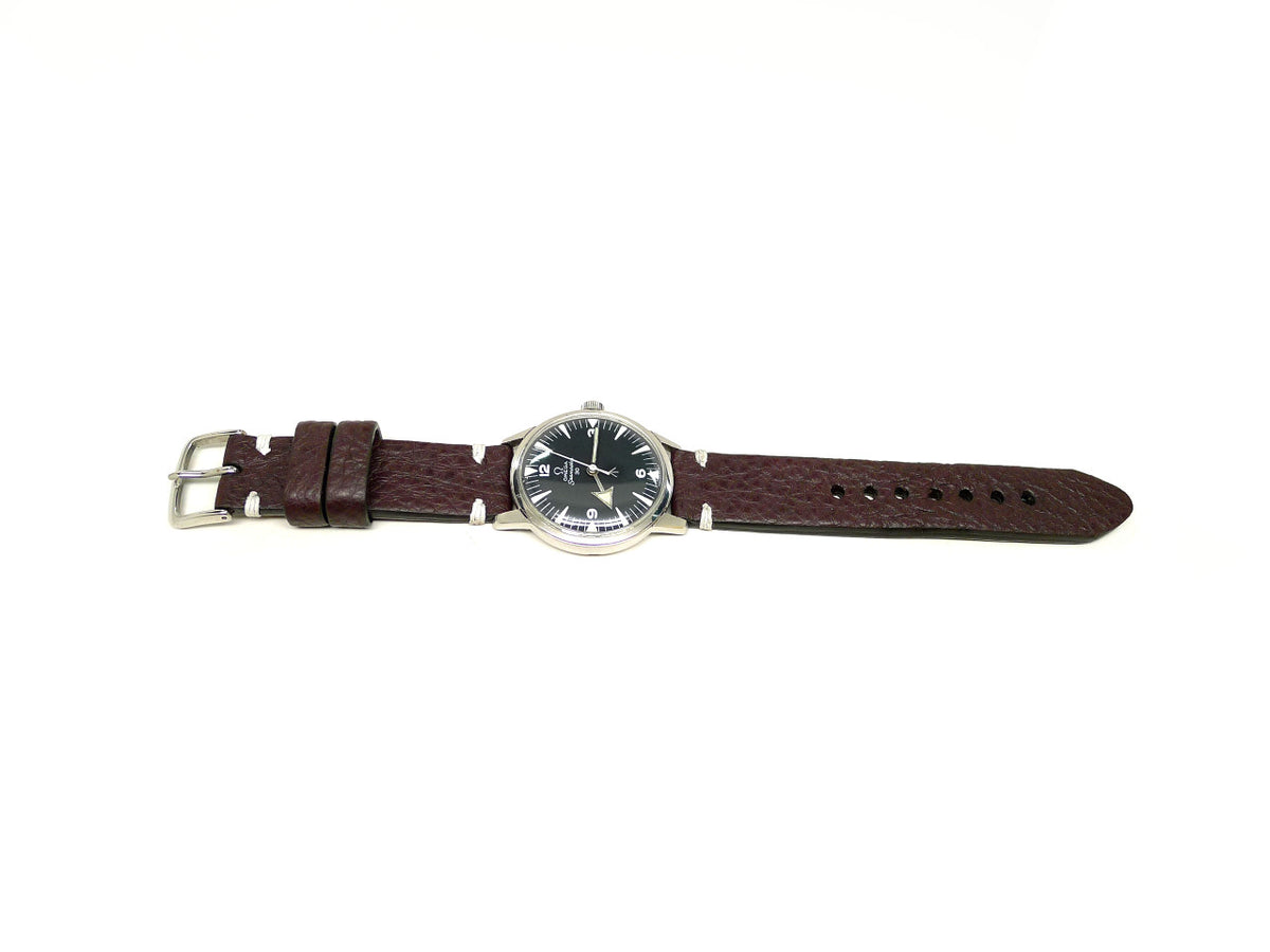 Tathway watch strap in dark burgundy with a textured surface and white accent stitches, shown fitted to a watch.