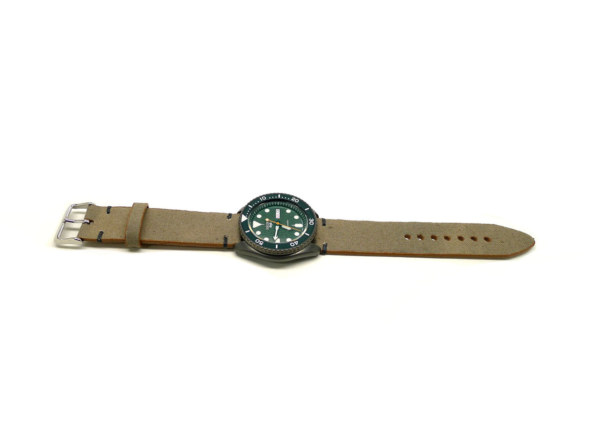 Ticonderoga watch strap in taupe with a textured surface and dark accent stitches, shown fitted to a watch.