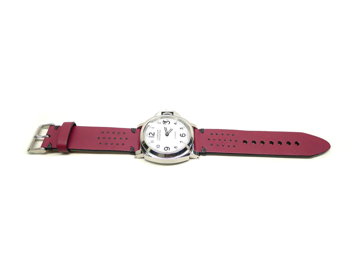 Vyolent watch strap in burgundy with small perforations and dark accent stitches, shown fitted to a watch.
