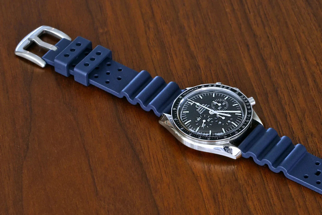 Blue FKM rubber watch strap fitted to a watch on wood