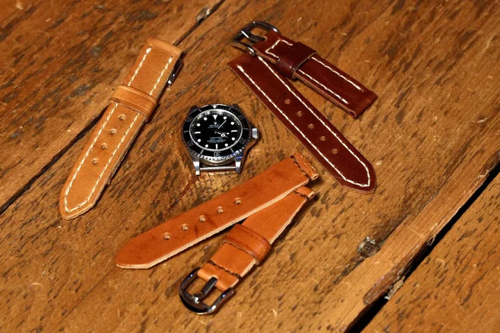 Finished leather watch straps arranged around a watch head